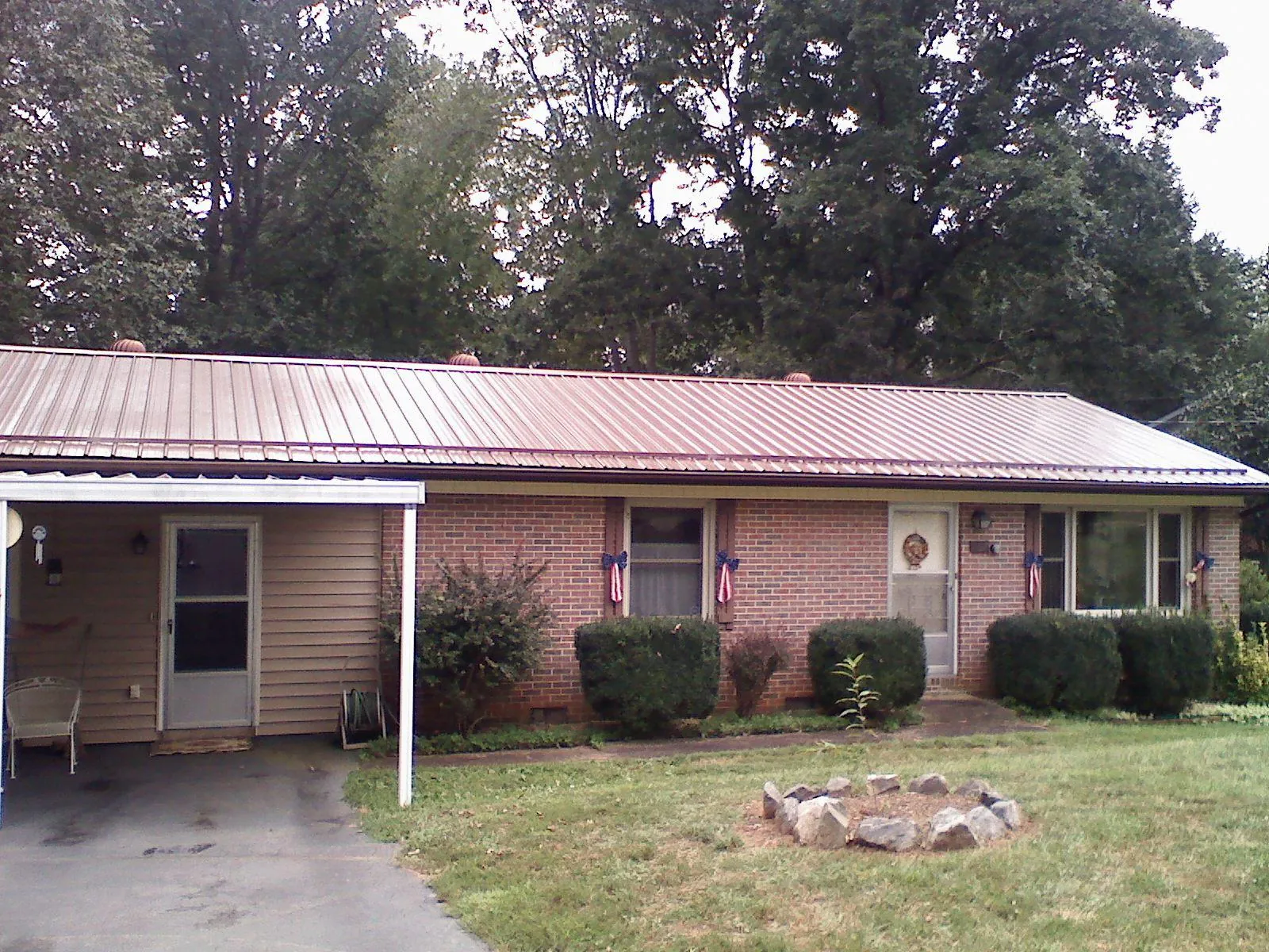Bronze metal roof and carport on a brick ranch home — Roof Repair work by our crew in Bulger